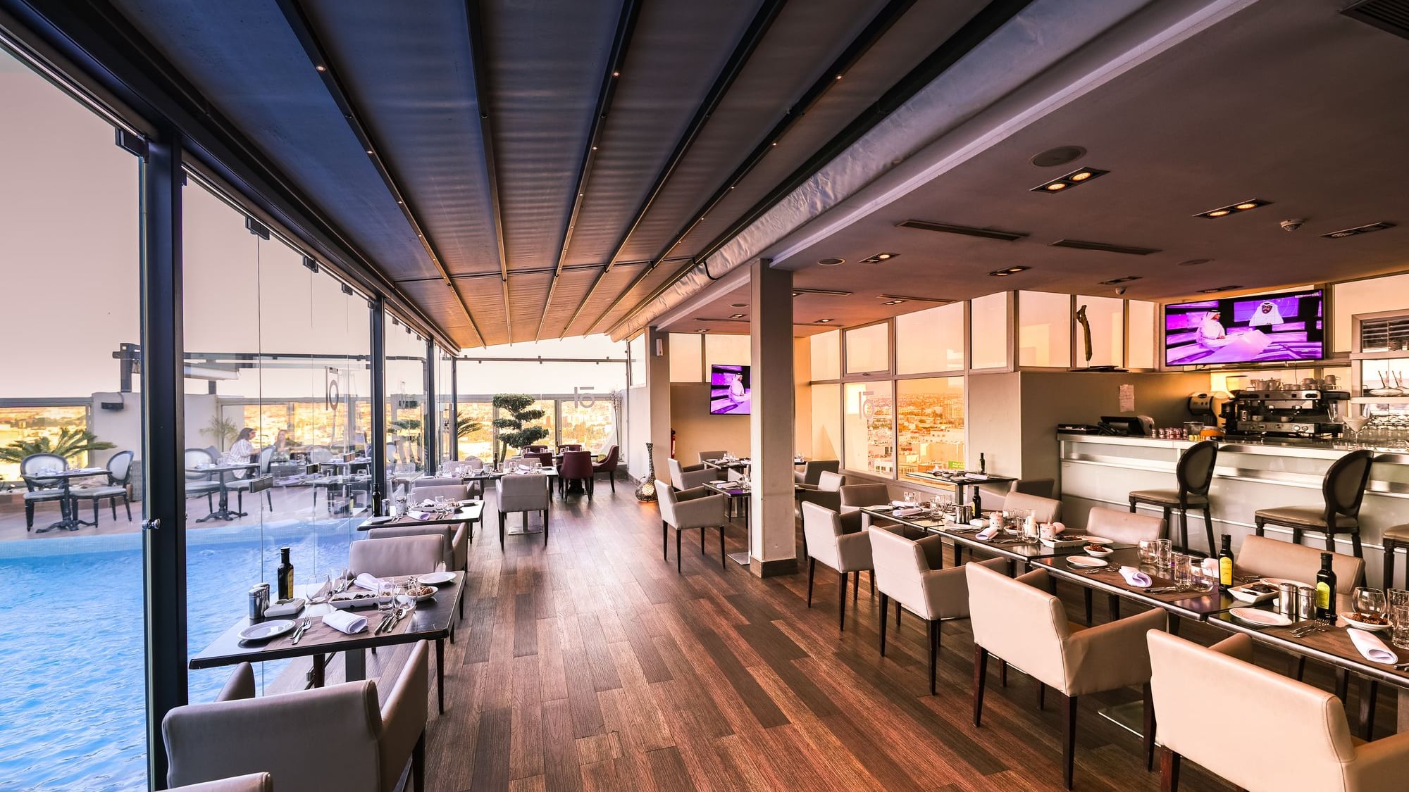 Restaurante moderno com grandes vidraças e vista para a cidade